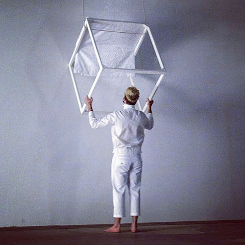 Performer Konstantinos Chaldaios is receiving a square set element from the floor above